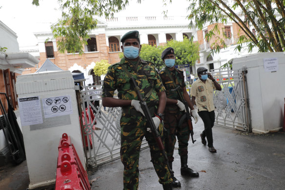 Sri Lankan government soldiers stand guard at the entrance to a ballot counting centre in Colombo on Thursday.