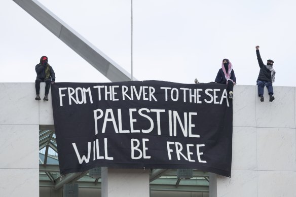 Pro-Palestine protesters unfurl banners at the front of Parliament House on Thursday.