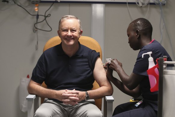 Opposition Leader Anthony Albanese receives a COVID-19 vaccination from registered nurse Yom Mapiou.