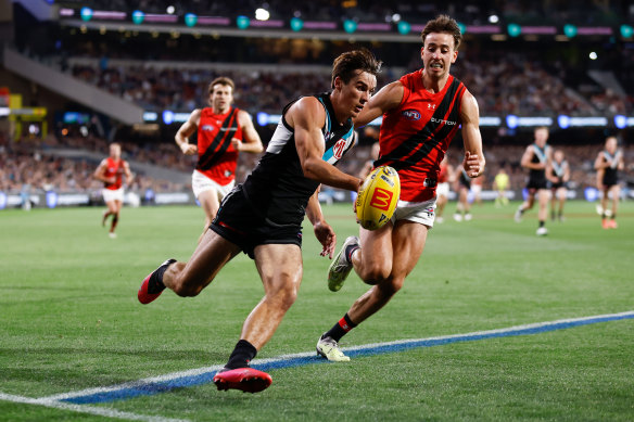 Connor Rozee of the Power is chased by Nic Martin of the Bombers.
