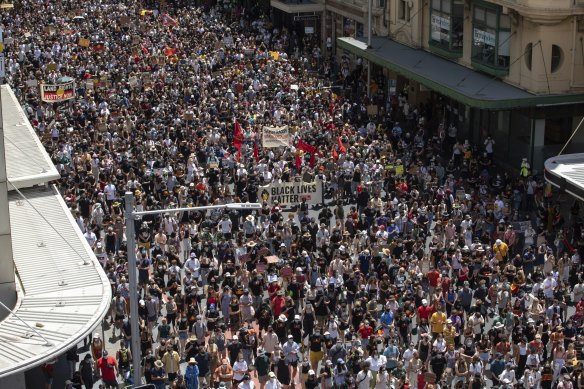 Invastion Day protesters move through the CBD in Sydney this morning.