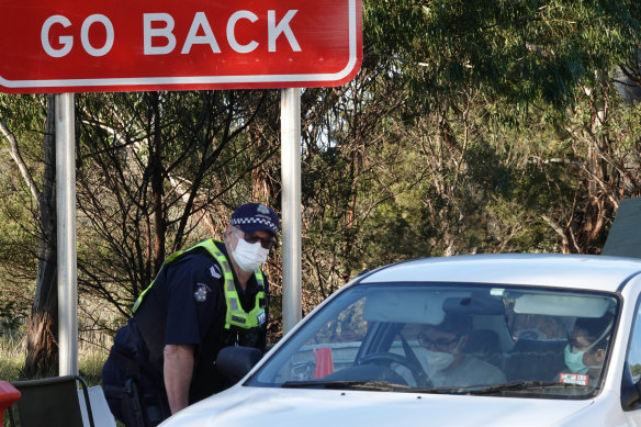 Victoria Police members stop motorists leaving metropolitan Melbourne at a checkpoint set up on the Calder Freeway between Sunbury and Gisborne earlier this month.