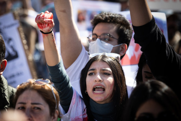 Women raised red-stained hands at the protest in Melbourne on Saturday.