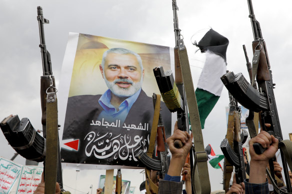 Yemeni protesters raise machine guns during a protest to condemn the killing of Ismail Haniyeh.
