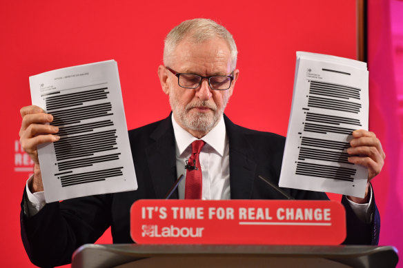 Labour leader Jeremy Corbyn brandishes documents he says prove the NHS is "up for sale". 