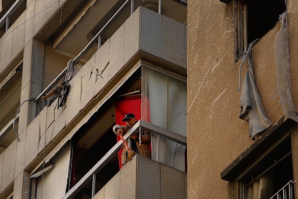 A man sweeps debris from his Beirut apartment, which was hit by an Israeli airstrike overnight (Beirut time). This is a part of the city where people thought they might be safe.