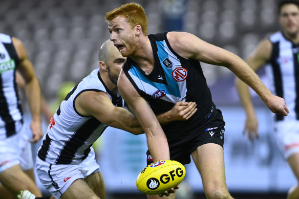 Willem Drew handballs while being tackled by Steele Sidebottom.