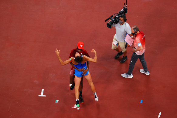 Mutaz Essa Barshim of Qatar (top) and Italy’s Gianmarco Tamberi embrace after their decision to share gold in the high jump on Sunday.