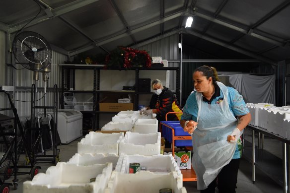 Staff at Tharawal Aboriginal Corporation in Airds prepare food care packages that will be delivered to elders.
