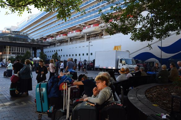 Ruby Princess passengers sit in Circular Quay after disembarking the ship on March 19.