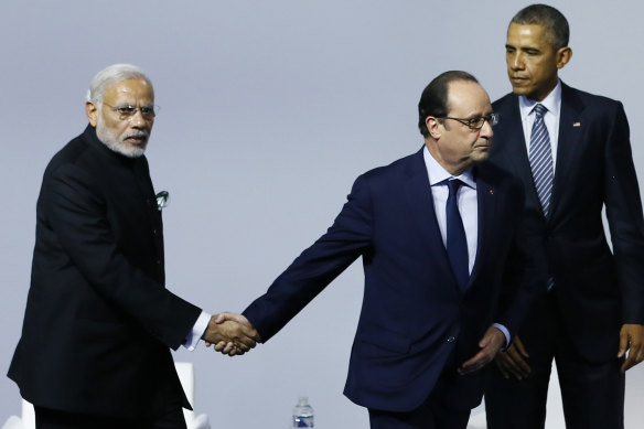 Then French president Francois Hollande, centre, shakes hands with Indian Prime Minister Narendra Modi as then US president Barack Obama looks on at COP21 in Paris in 2015. 