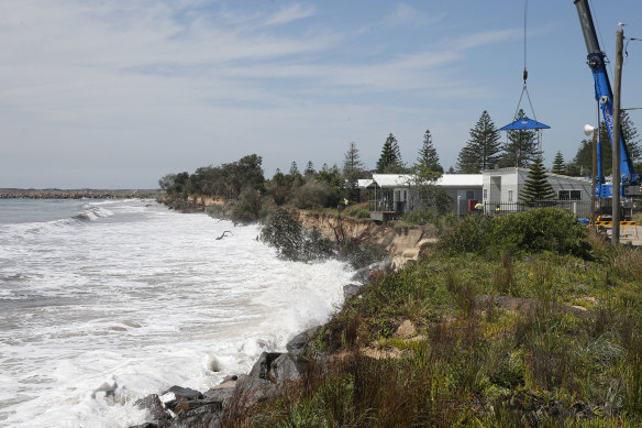 Newcastle City Council use a crane to move cabins from the council owned Stockton Caravan Park as erosion from large swell threatens to undermine them into the sea.