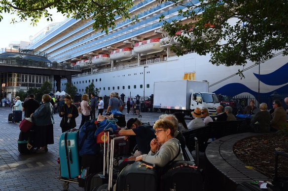 Ruby Princess passengers sit in Circular Quay after disembarking the ship on March 19.