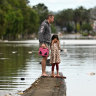 A father and daughter inspect a flooded Lismore street in March.