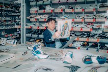 Toshikazu Kayano, former ASICS footwear designer known for creating the iconic Kayano series, surrounded by past ASICS models while reviewing design sketches at the ASICS Institute of Sport Science in Kobe, Hyogo Pref., Japan.