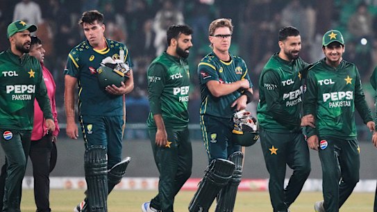 Australia’s Xavier Bartlett, second left, and Adam Zampa, third right, and Pakistani players walk off the field on the end of their T20 cricket match in Lahore, Pakistan.