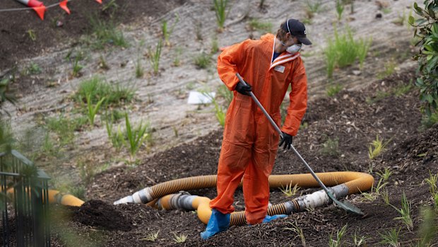 A worker removes mulch at Rozelle Parklands, which was closed in 2024 after asbestos was found in several areas.