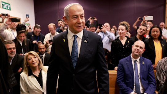 Israeli Prime Minister Benjamin Netanyahu, center, arrives to attend a hearing at the district court for his long-running trial for alleged corruption, in Tel Aviv, Israel, Tuesday, Dec. 10, 2024.  (Menahem Kahana/Pool Photo via AP)
