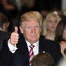 Donald Trump gives a thumbs-up at a meal.