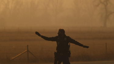 A police officer secures an intersection in Louisville, Colorado, as wildfires force residents to evacuate.