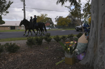 Police on horseback pass the crime scene on Wednesday afternoon.