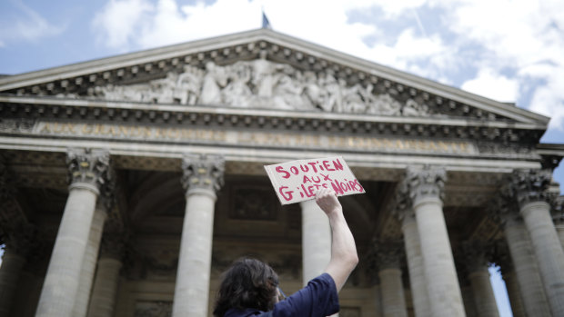 A man holds a placards reading "Support the black vest" outside the Pantheon monument on Friday.