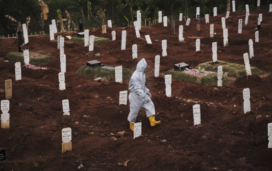 A municipal cemetery worker walks through a special cemetery for suspected Covid-19 victims in Jakarta, Indonesia, in September.