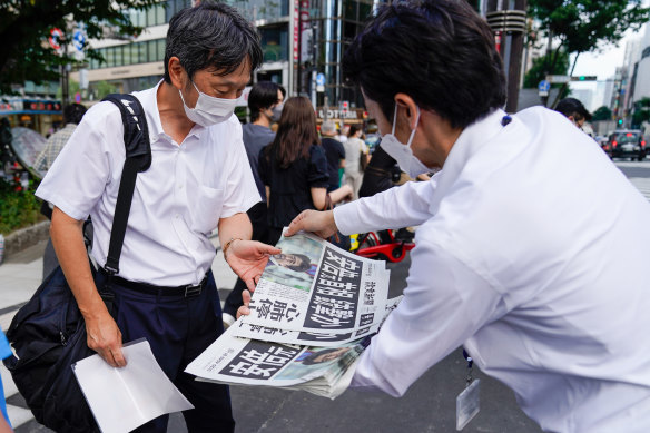 A seller hands an extra edition of the news of the attack on Shinzo Abe, in Tokyo on Friday.