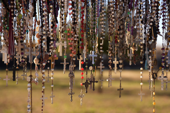 Crosses and rosaries hang in front of Robb Elementary in memorial to victims of the school shootings in Uvalde, Texas.