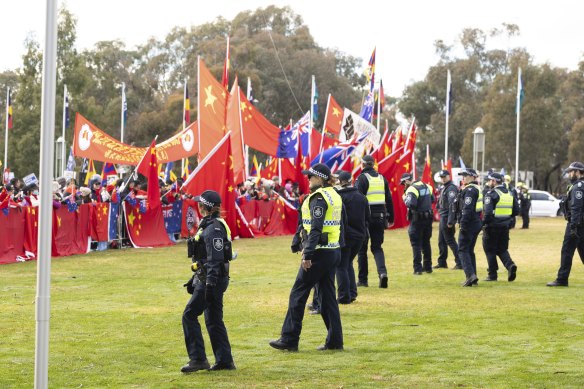 Police observe protesters and pro-China supporters on the front lawn of Parliament House today.