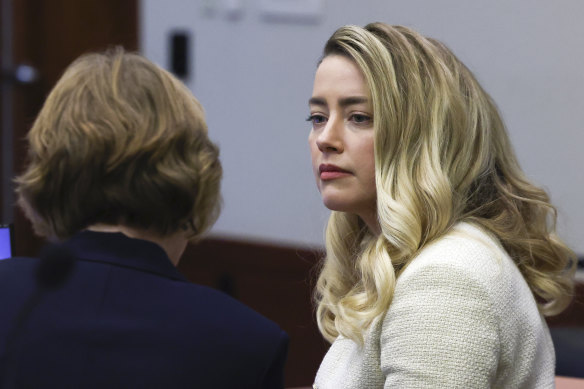 Actor Amber Heard speaks to her attorney.