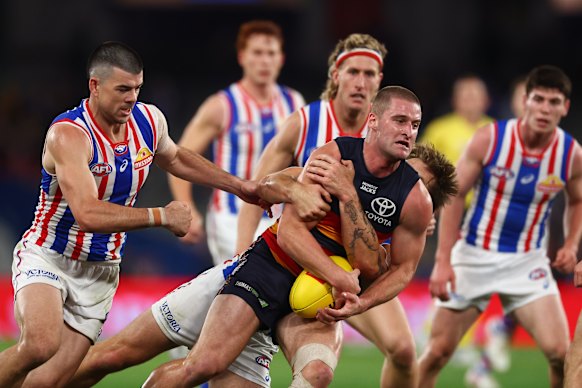 Sam Berry of the Crows is tackled by Rhylee West of the Bulldogs.