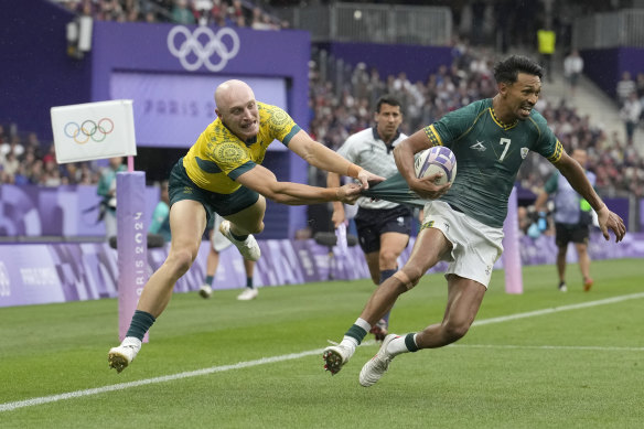 South Africa’s Tristan Leyds, right, is grabbed by his shirt by Australia’s James Turner during the men’s bronze medal Rugby Sevens match.