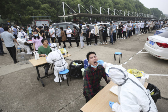 Workers line up for a coronavirus test at a large factory in Wuhan, China.