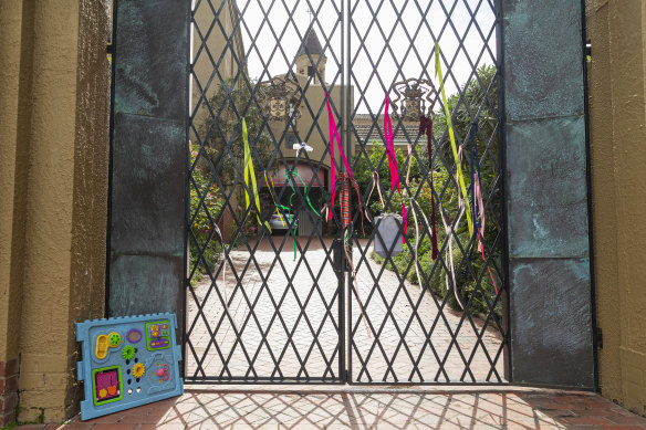 Ribbons and a child's toy are seen at the gate of the Carmelite Monastery in Kew.