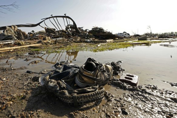 A pair of sneakers and pants lay in front of the skeletal remains of the underside of a mobile home in Rolling Fork, Mississippi.