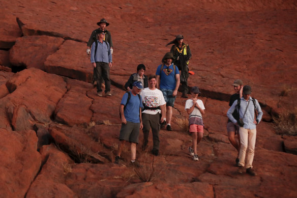 The last group of tourists to descend Uluru on Friday.