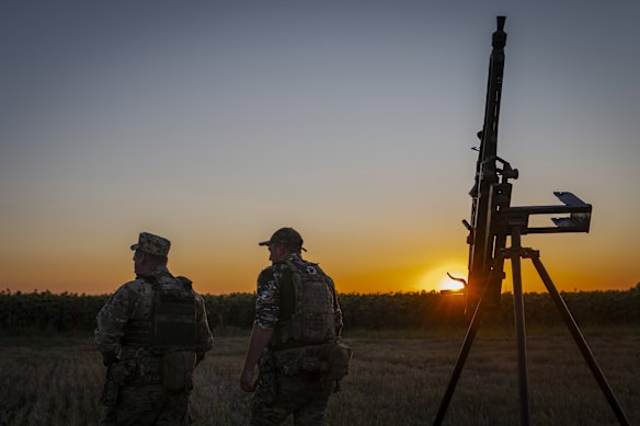 Os serviços ucranianos ficam do caminhão armado no escritório noturno na área de Chernihiv, na Ucrânia, em 12 de agosto.