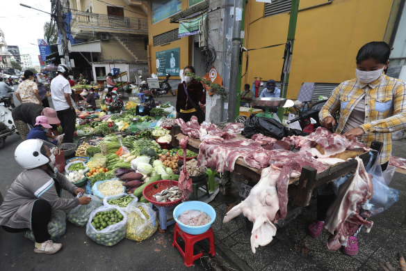 Local vendors sell pork meat and vegetables on a sidewalk as the main market remained closed during a lockdown in downtown Phnom Penh, Cambodia.