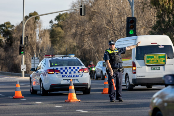 Victoria Police stop cars entering The Causeway at a checkpoint between Albury and Wodonga. 