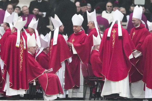 Upon arriving at Pope Benedict's Funeral Mass, members of the church are shown to their seats.