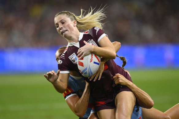 Tarryn Aiken of the Maroons is tackled. 