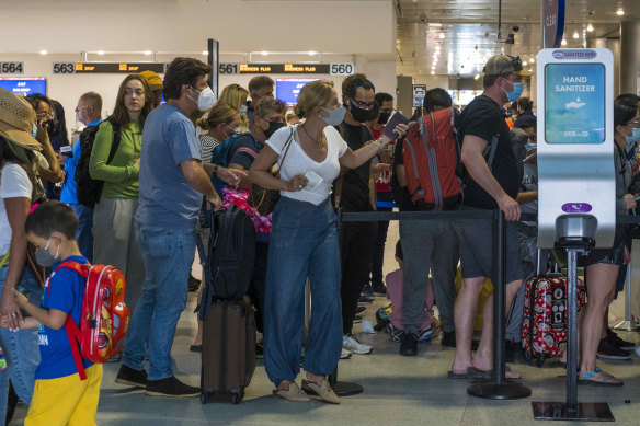 Put it on or leave it off? Passengers at the departure lounge of Miami International Airport in Florida.