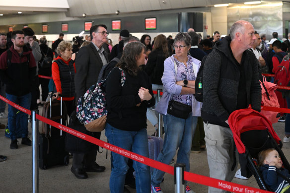 Qantas passengers queue after a security breach forced everyone in its terminal to be rescreened by security.