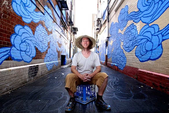 Artist Jason Wing in Kimber Lane in Chinatown with his street artwork titled “In Between Two Worlds”.