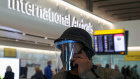 A man wears a face covering at Heathrow airport in London.