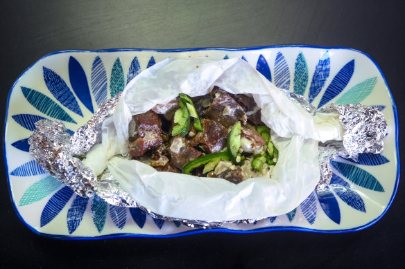 A parcel of smoked goat meat with mayonnaise and chilli.