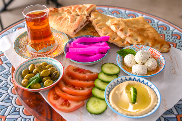 A platter with handmade pastries filled with spinach, meat and cheese.