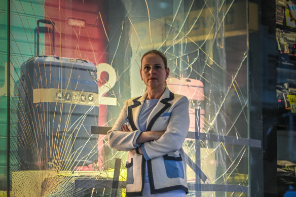 Anja Faustein in front of a smashed window.