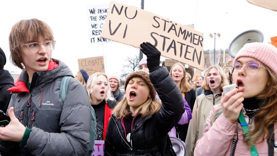 Climate activist Greta Thunberg, centre, attends a demonstration by youth-led organisation Aurora, in Stockholm, Sweden, in November. Her sign says “Now we sue the state”. 